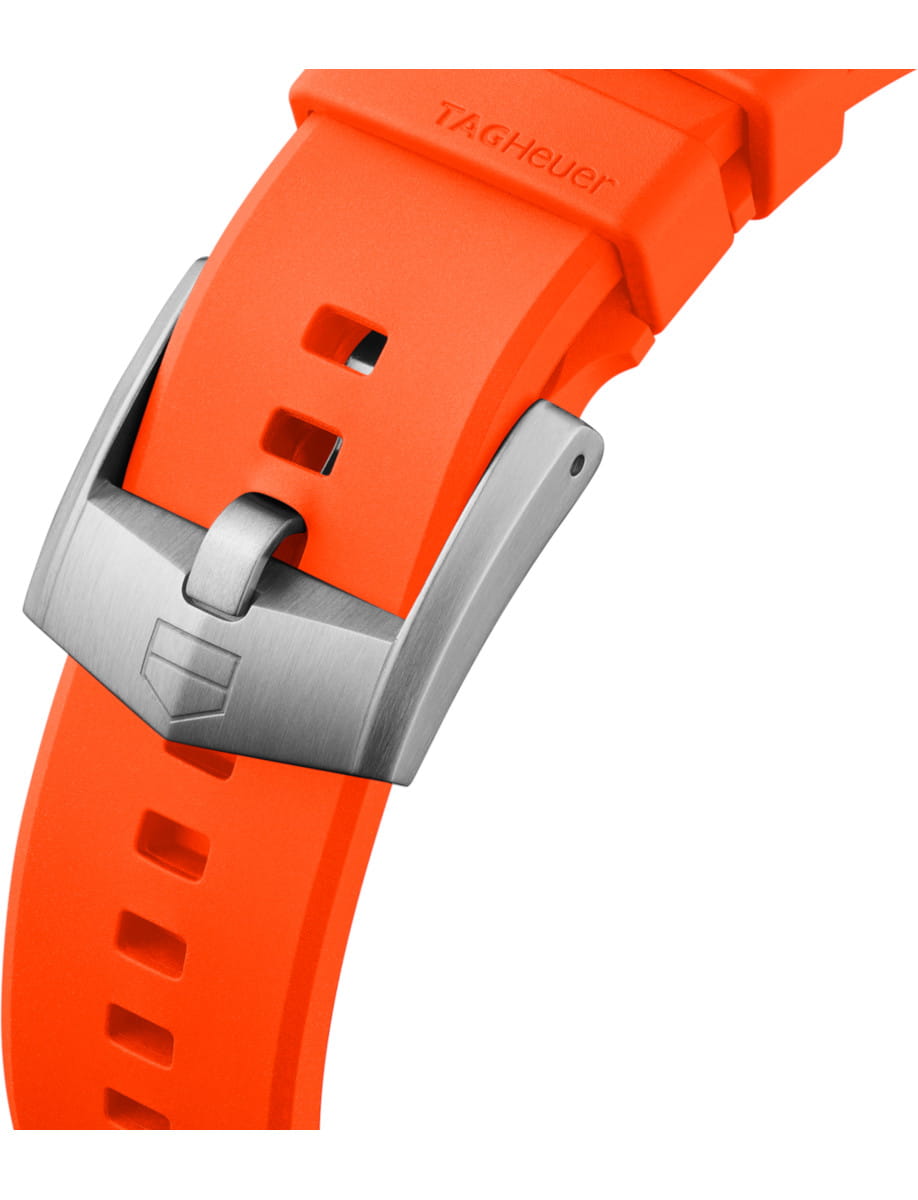 Close-up of an orange silicone watch strap with a silver metal buckle and TAG Heuer branding