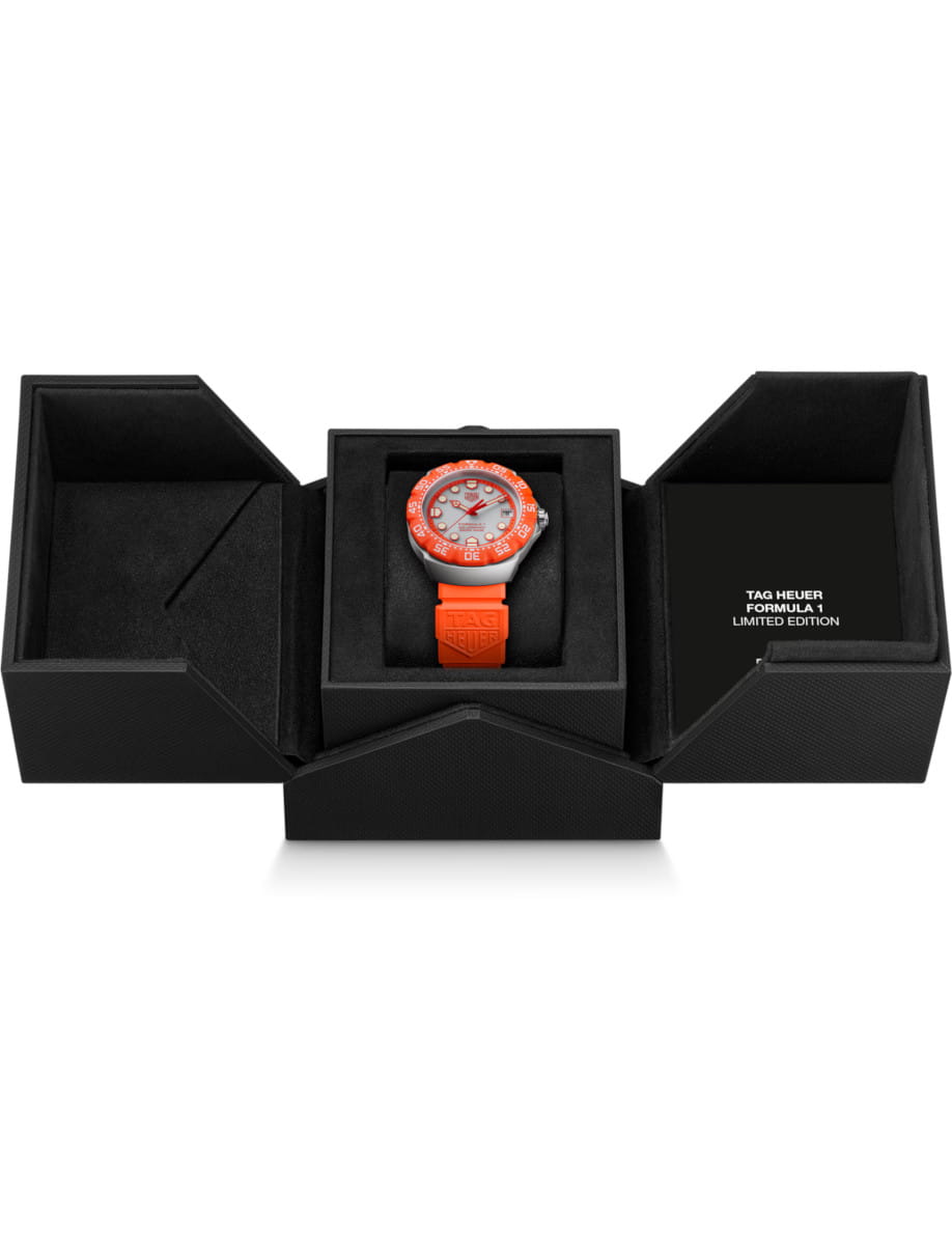 Orange TAG Heuer Formula 1 limited edition watch in a black presentation box with orange strap visible in the center of a multi-compartment case.