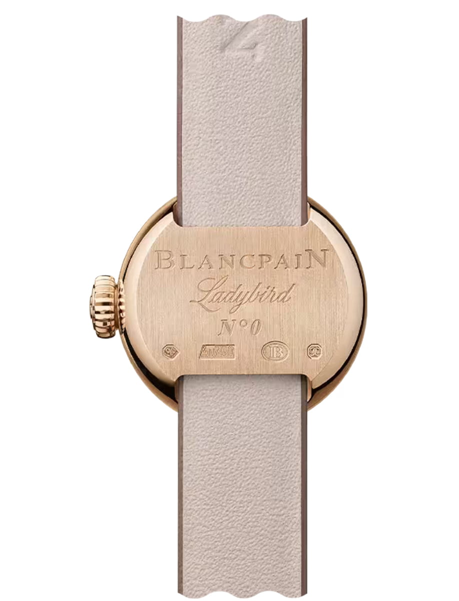 Rose gold Blancpain Ladybird watch case back with engraved logo and 'N°0', beige leather strap visible.