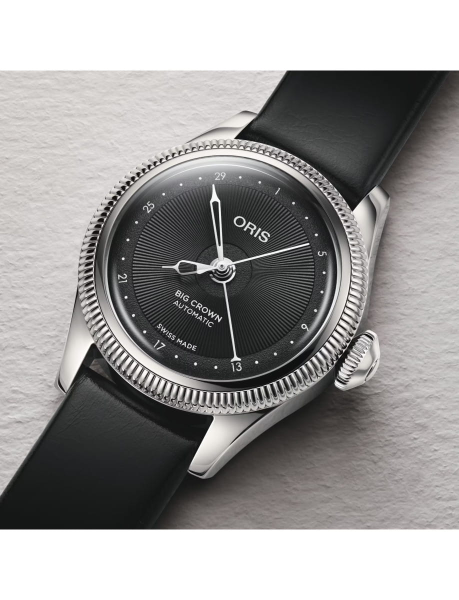 Close-up of an Side view of Oris Big Crown automatic wristwatch with a black grained dial, stainless steel case, and black leather strap.