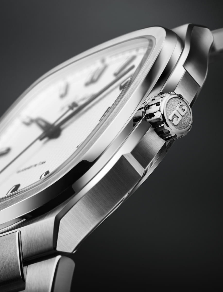 Close-up of a stainless steel wristwatch, focusing on the crown and polished case.