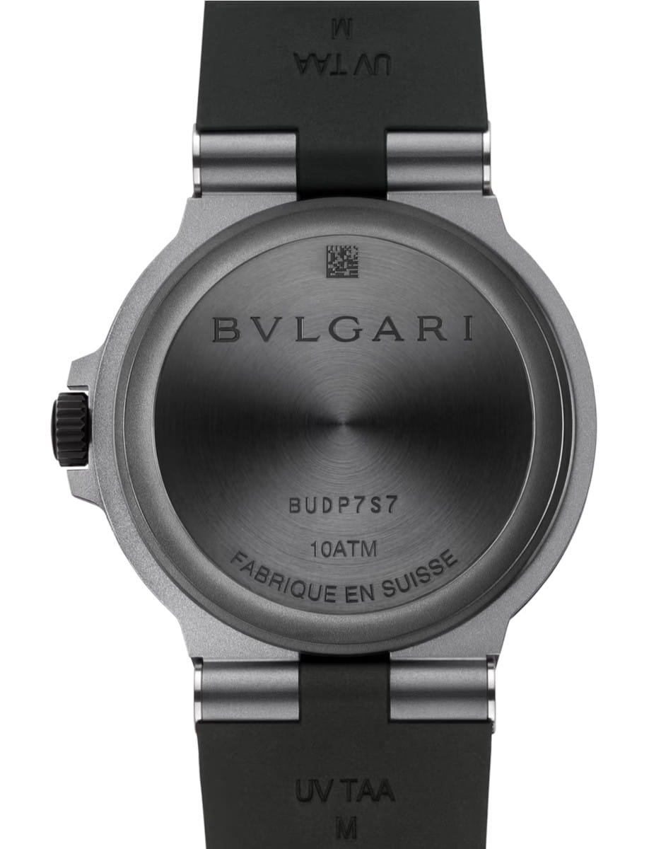 Back of a BVLGARI wristwatch with brushed titanium case, engraved logo, and 'FABRIQUE EN SUISSE' text along the rim; black strap attached on top and bottom.