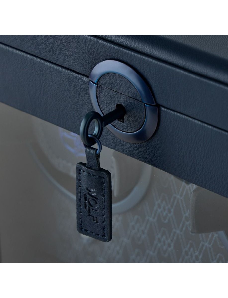 Close-up of a blue circular lock on a blue suitcase with a key inserted.