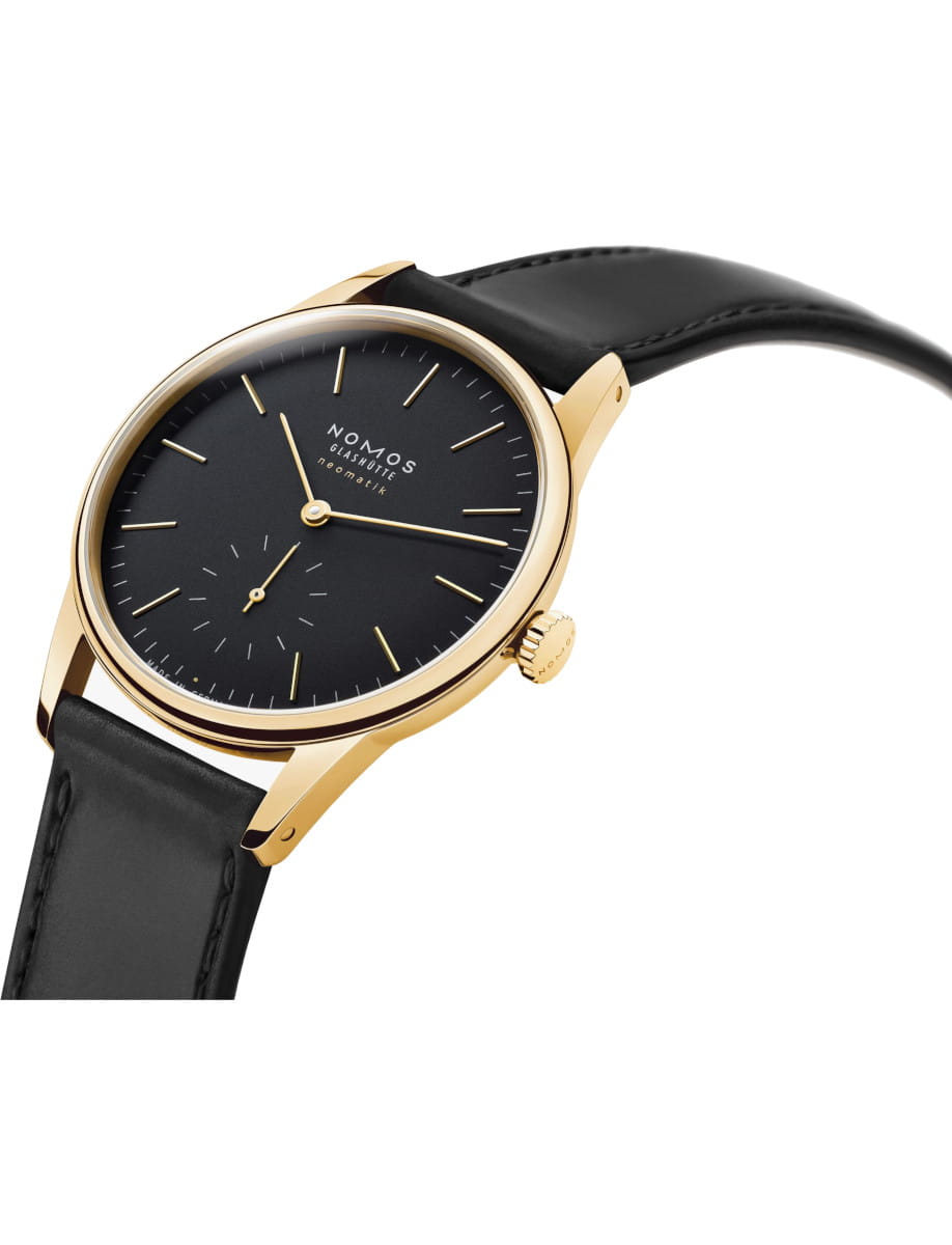 Gold watch with black dial, minimalist design, and black leather strap