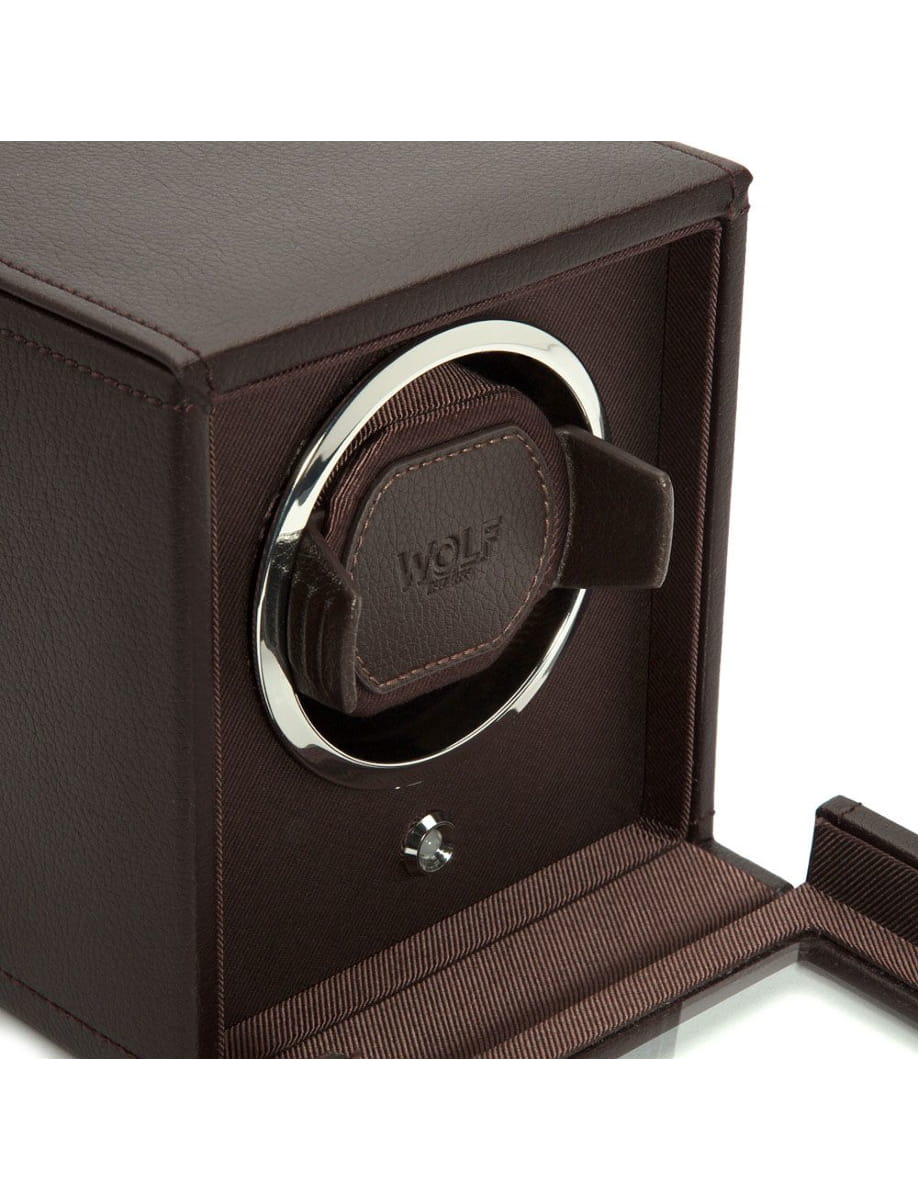 Brown leather watch box with a circular chrome ring and a padded watch holder labeled WOLF inside.