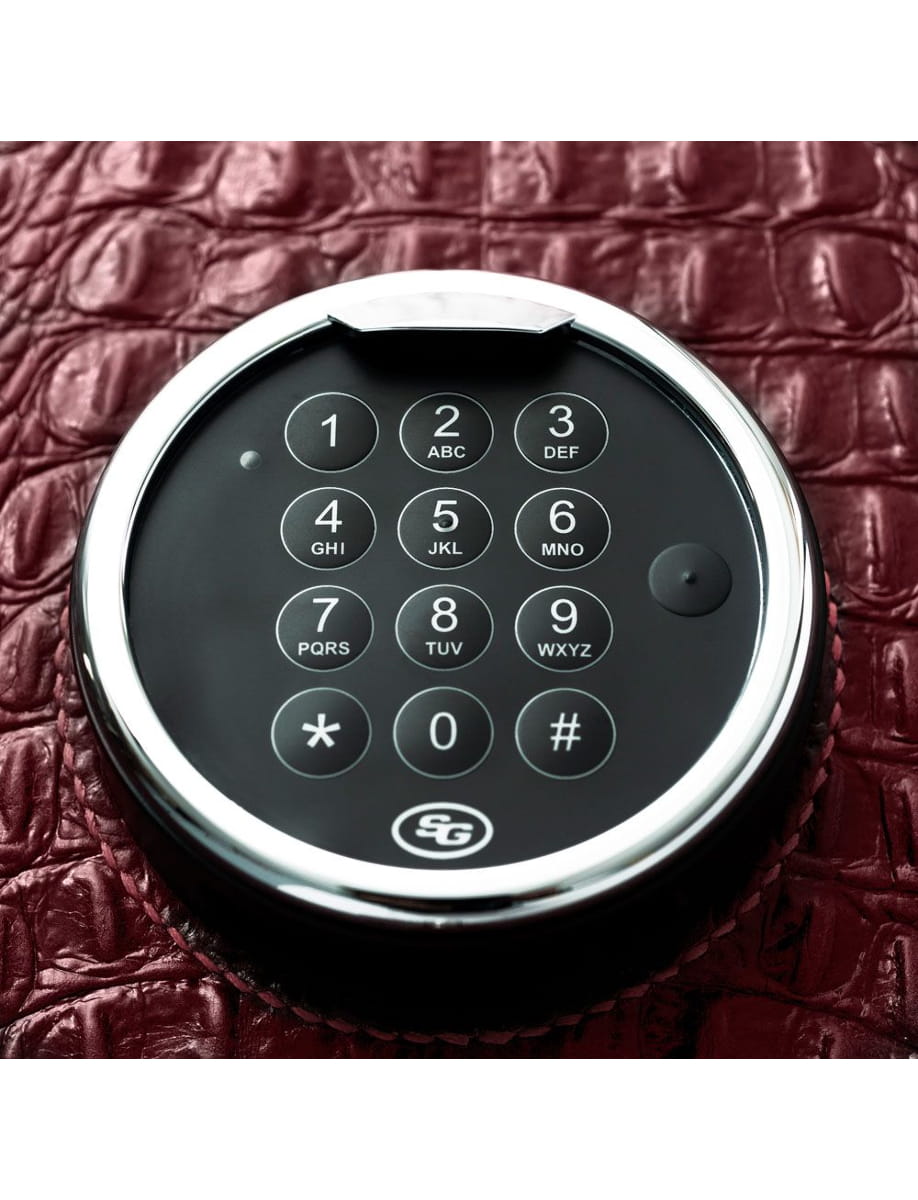 Circular electronic keypad with numbered keys on a textured black leather surface. Newline exact layout shows 1-9, *, 0, # on a round device.