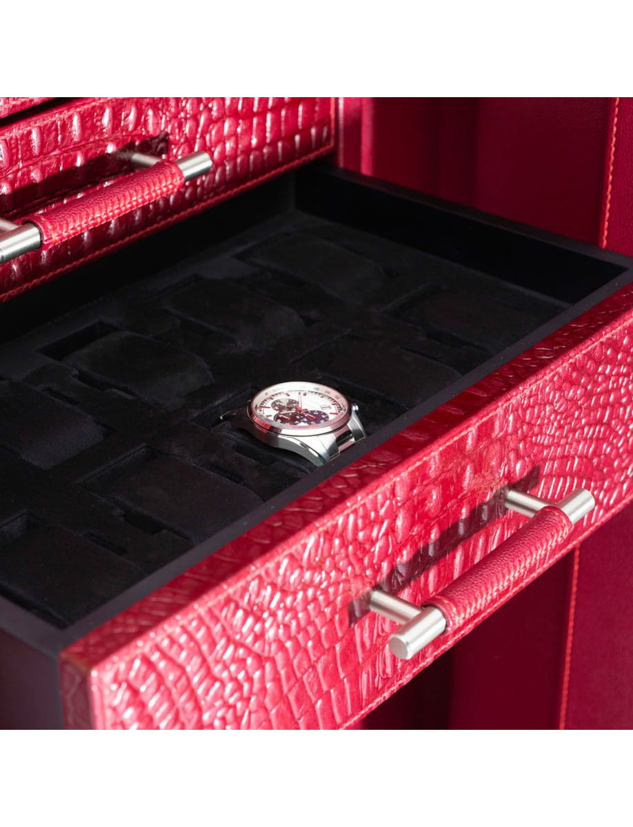 Wristwatch resting in a black foam tray inside a red textured jewelry box with metal handles