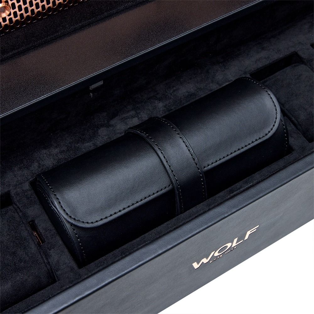 Black leather cylindrical accessory case with stitching, placed inside a plush presentation box marked 'WOLF'.