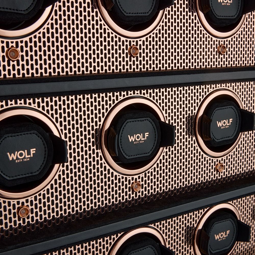 Close-up of a perforated metallic panel with circular vents and black padded rings labeled WOLF EST 1834