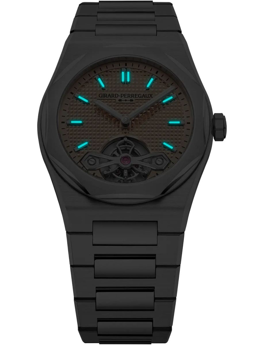 Dark, matte black wristwatch with turquoise luminous hour markers and hands; skeleton dial shows the tourbillon at 6 o'clock; brand name Girard-Perregaux on dial
