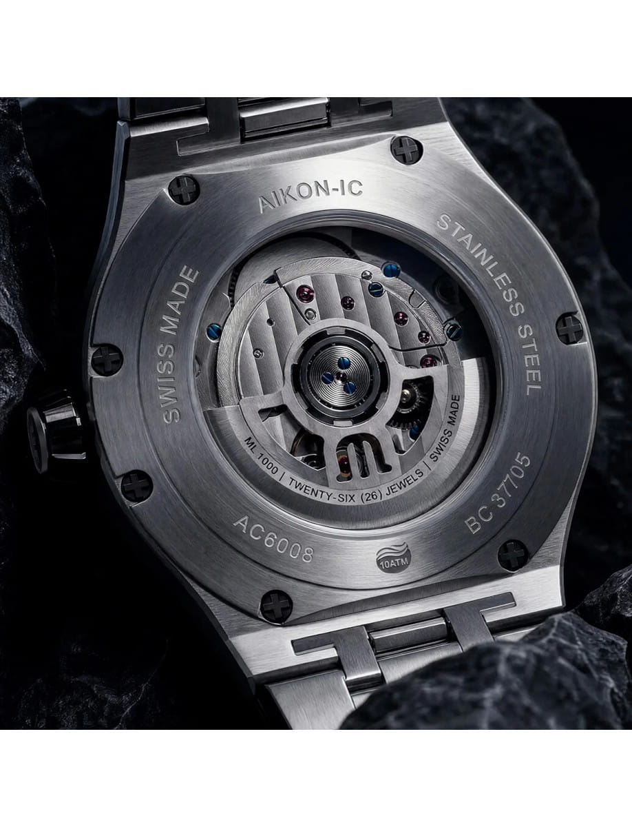 Close-up of a stainless steel watch back (Aikon-IC), showing the exposed mechanical movement and engraved details like Swiss Made and 10ATM.]}