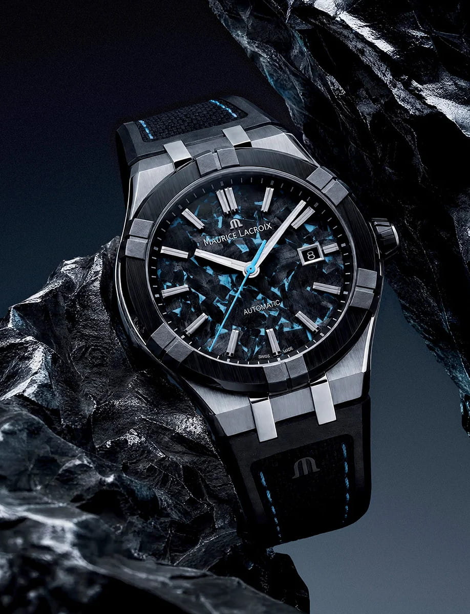 Close-up of a Maurice Lacroix automatic wristwatch with a stainless steel case, ceramic bezel, frozen carbon dial, and bi-rubber strap with imitation nylon-textured rubber