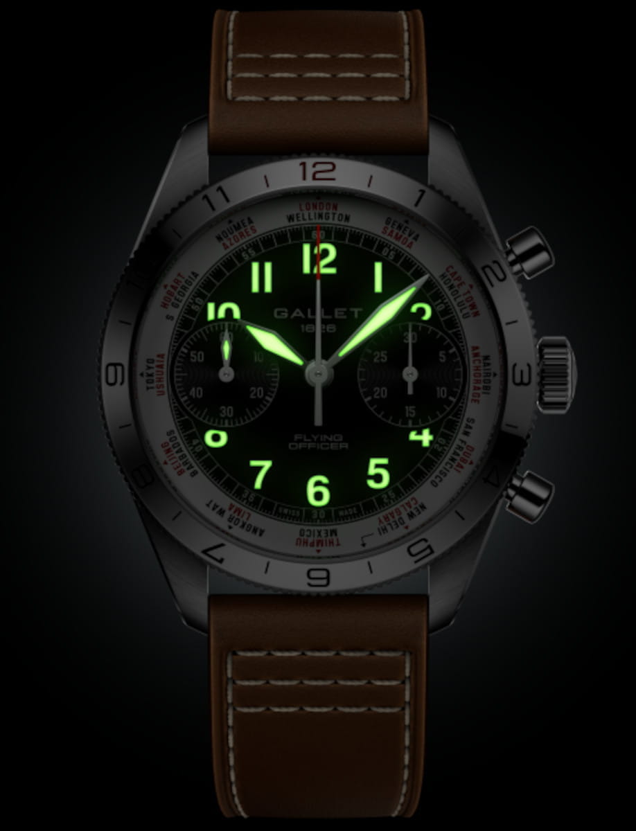 Close-up of a black-dial wristwatch with glowing green numerals and a brown leather strap.