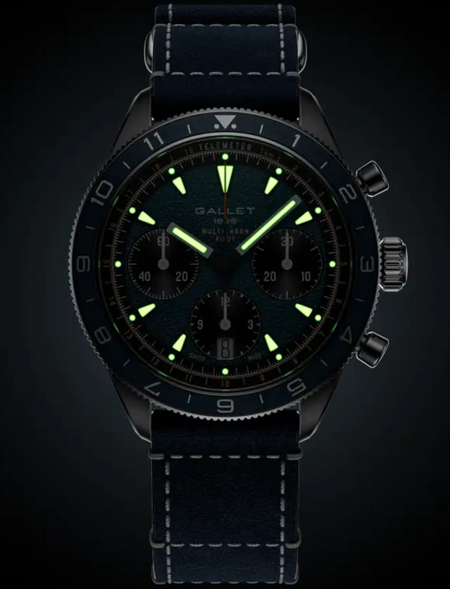 Gallet chronograph wristwatch with glowing green hands and markers, blue stitched strap, and three subdials on the dial.