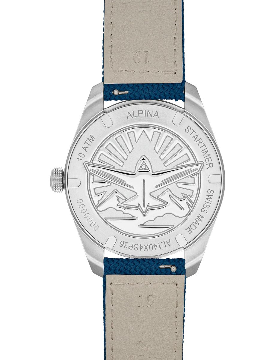 Back of Alpina Startimer watch with engraved airplane emblem and edge text; blue strap visible on both sides.