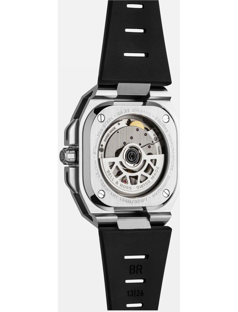 Stainless steel wristwatch with a transparent case back showing the automatic movement and rotor, attached to a black rubber strap.