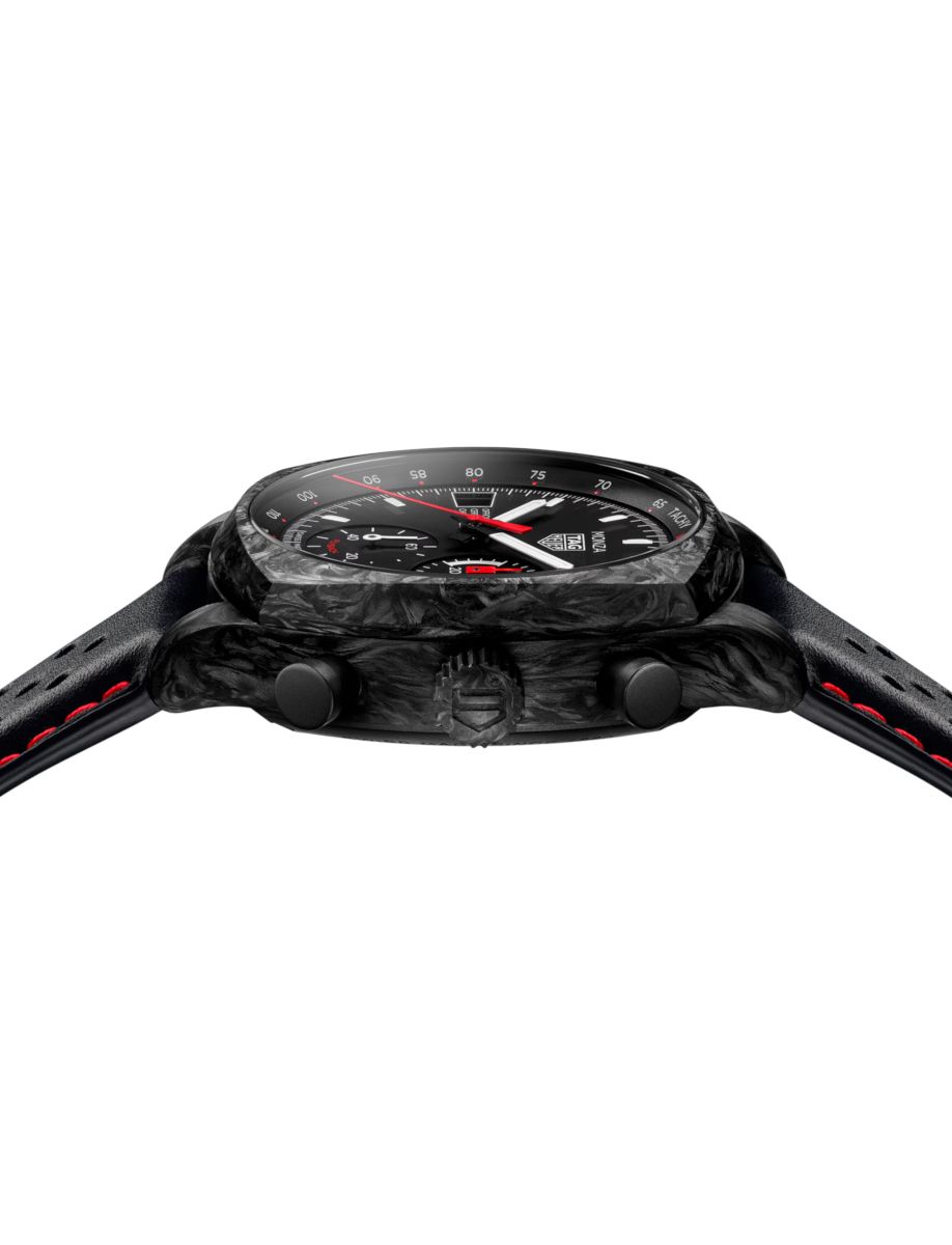 Side view of a black sports watch with a carbon-fiber case and red accents, leather strap with red stitching