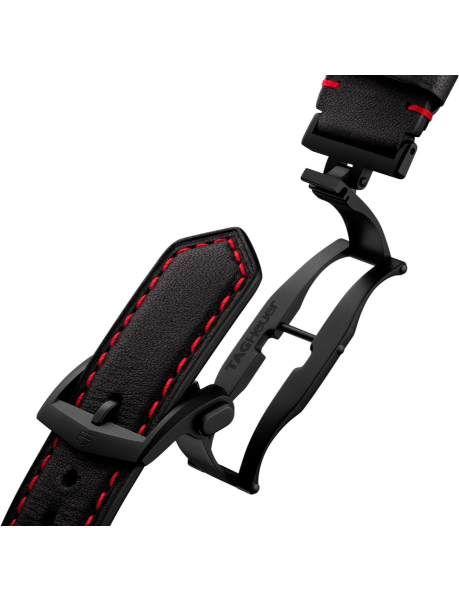 Black leather watch strap with red contrast stitching and a folding deployant clasp on a white background, showing the connection to a wristwatch band.