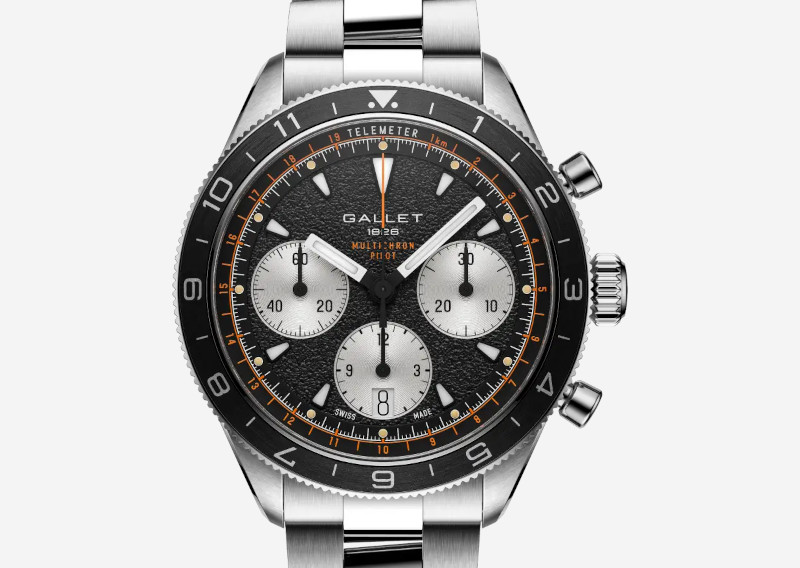 Gallet stainless steel chronograph wristwatch with black textured dial, three silver subdials, orange accents, bezel numbers, and date window at 6 o'clock.