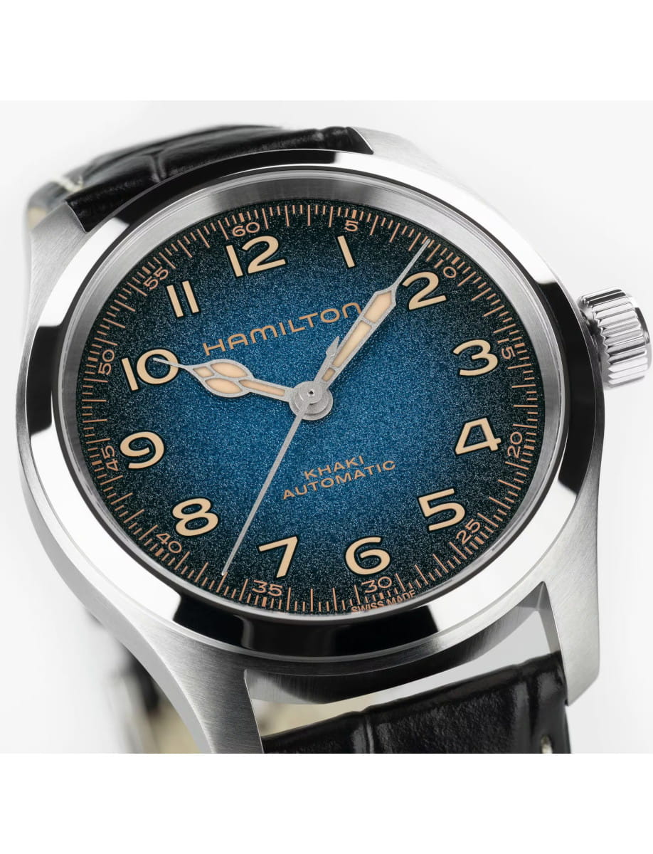 Close-up of a blue dial Hamilton Khaki Automatic wristwatch with a stainless steel case, Super-LumiNova numerals, and black leather strap.