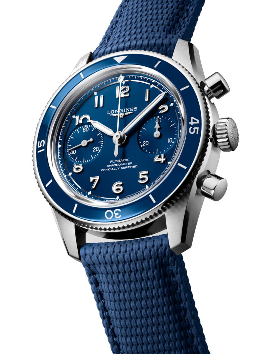 Side view of Longines wristwatch with blue dial, stainless steel case and ceramic bezel, and blue fabric strap.