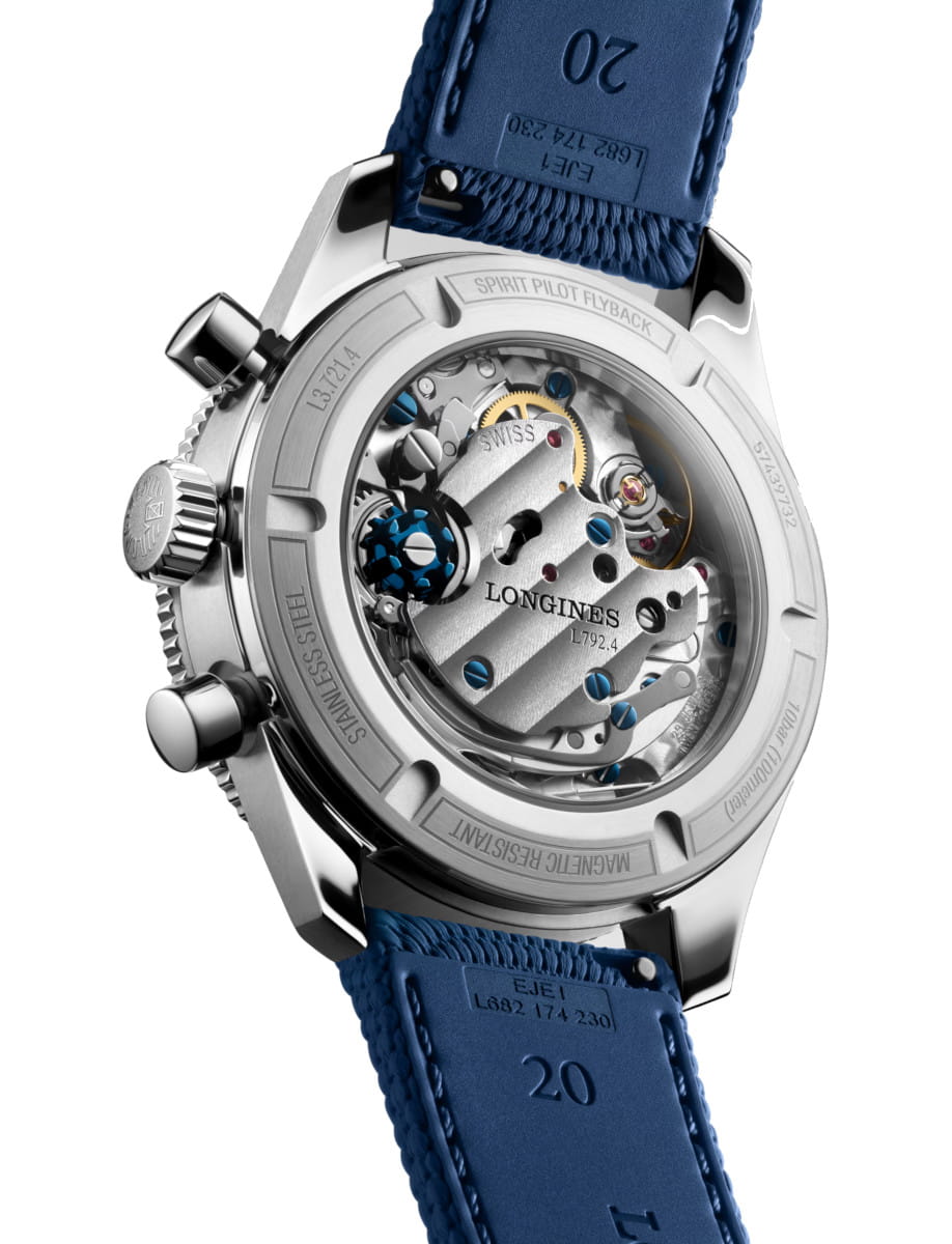 Transparent-case back of a stainless steel Longines watch showing intricate mechanical movement and blue screws with a blue rubber strap