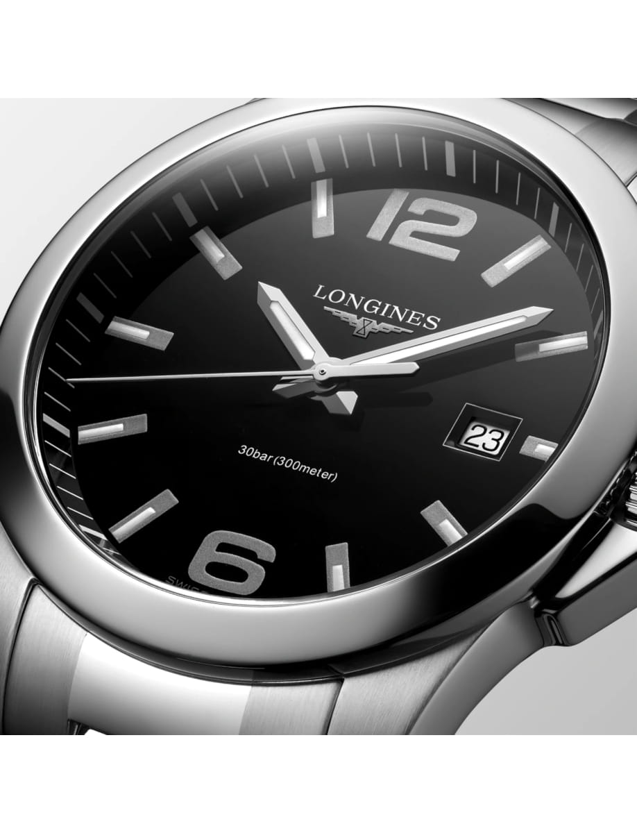 Close-up of a stainless steel Longines wristwatch with a black dial, silver hands, and a date window showing 23.