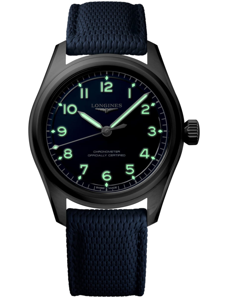 Night view of Longines wristwatch with a stainless steel case, blue dial, luminous green numerals, and a blue fabric strap; chronometer officially certified.