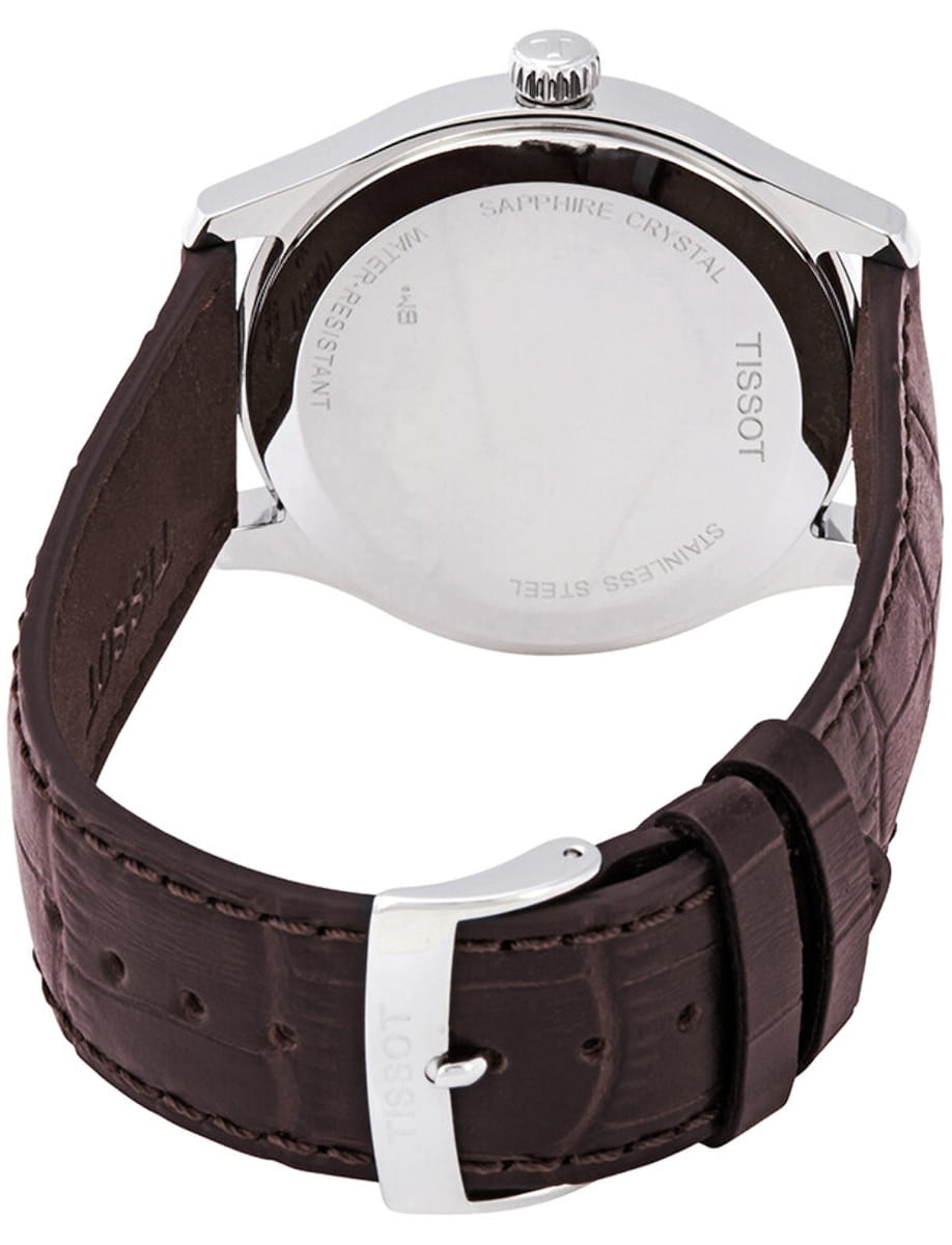 Back view of a silver wristwatch with a brown leather strap; Tissot engraved on the case back.