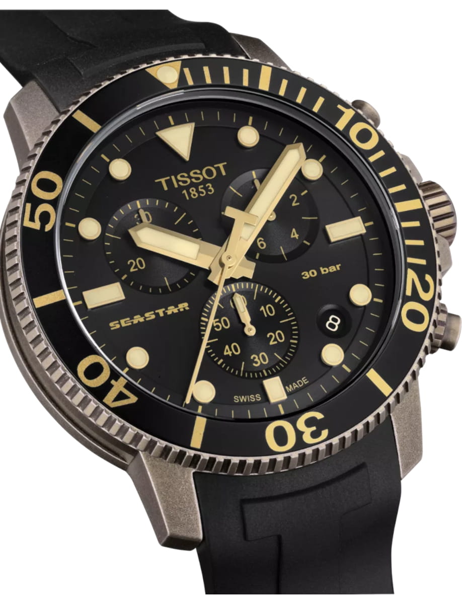 Tissot Seastar dive watch with black dial, gold indices, and a unidirectional bezel showing date at 3 o'clock on a black rubber strap