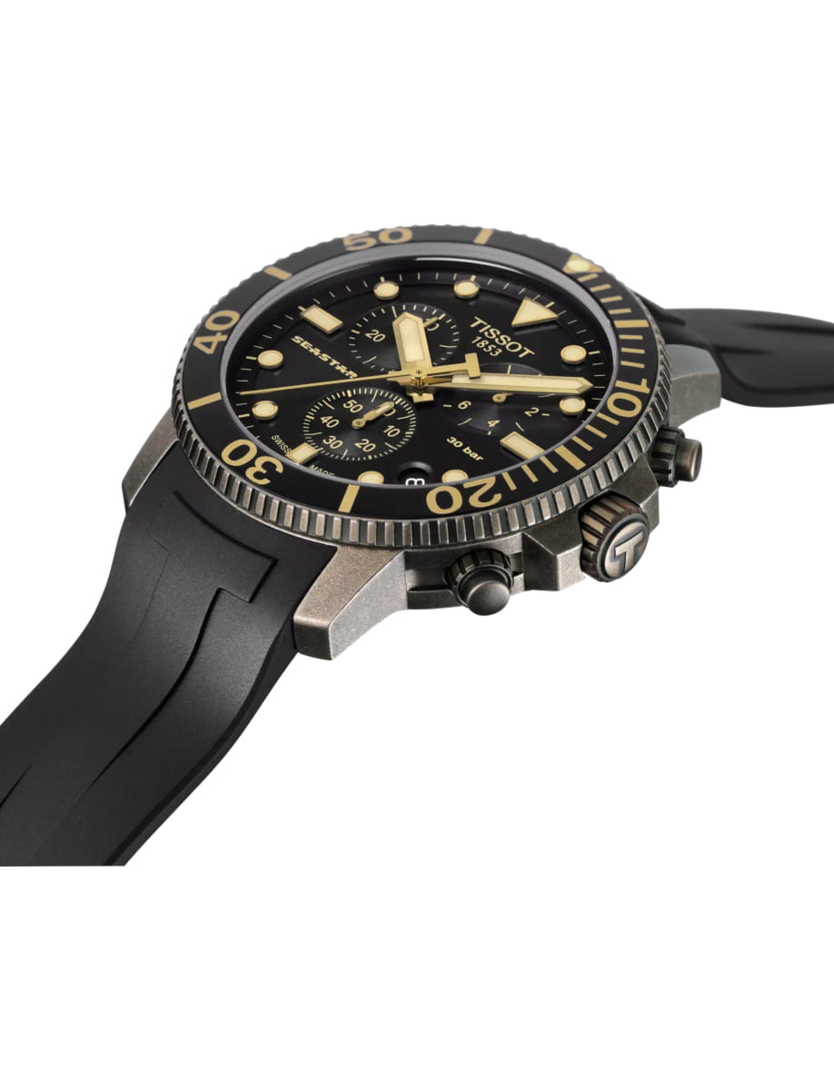 Black and gold Tissot diving watch with a black dial, chunky bezel, and rubber strap photographed at an angle