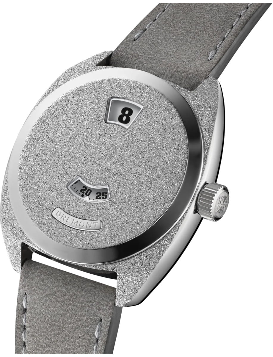 Side view of a stainless steel textured Bremont watch dial with an hour window showing 8 and minute 20-25.