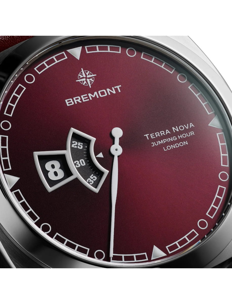 Close-up of a Bremont Terra Nova watch face with a burgundy dial, white markers, and a date window showing 8.