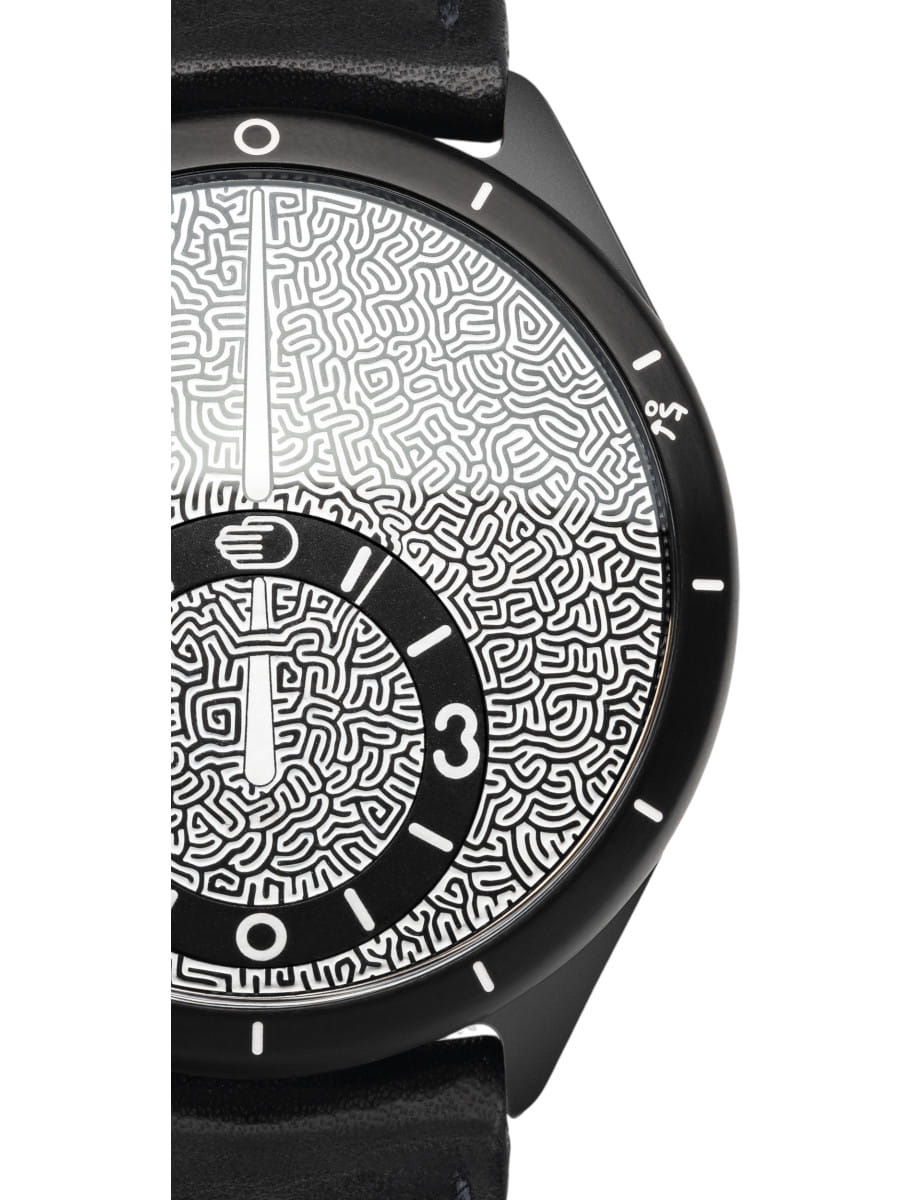 Close up of a Ressence wristwatch with Grade 5 Titanium case, black dial, and black calf leather strap.