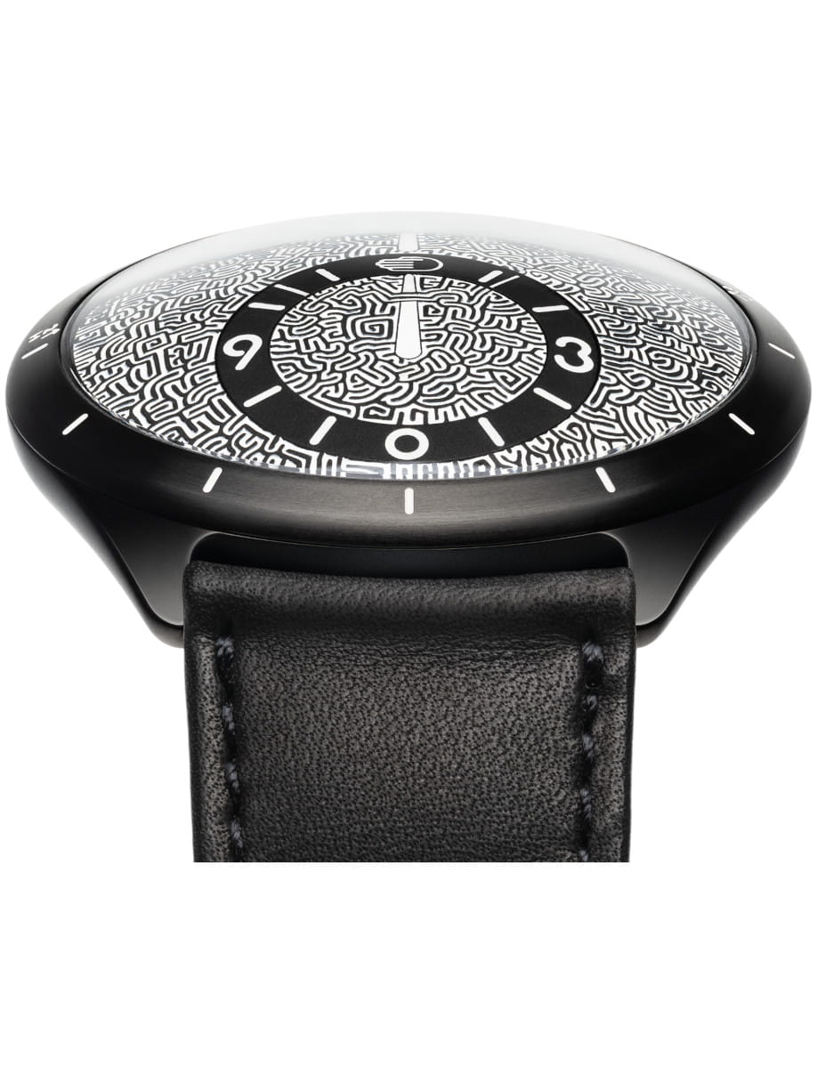 Close up of a Ressence wristwatch with Grade 5 Titanium case, black dial, and black calf leather strap.