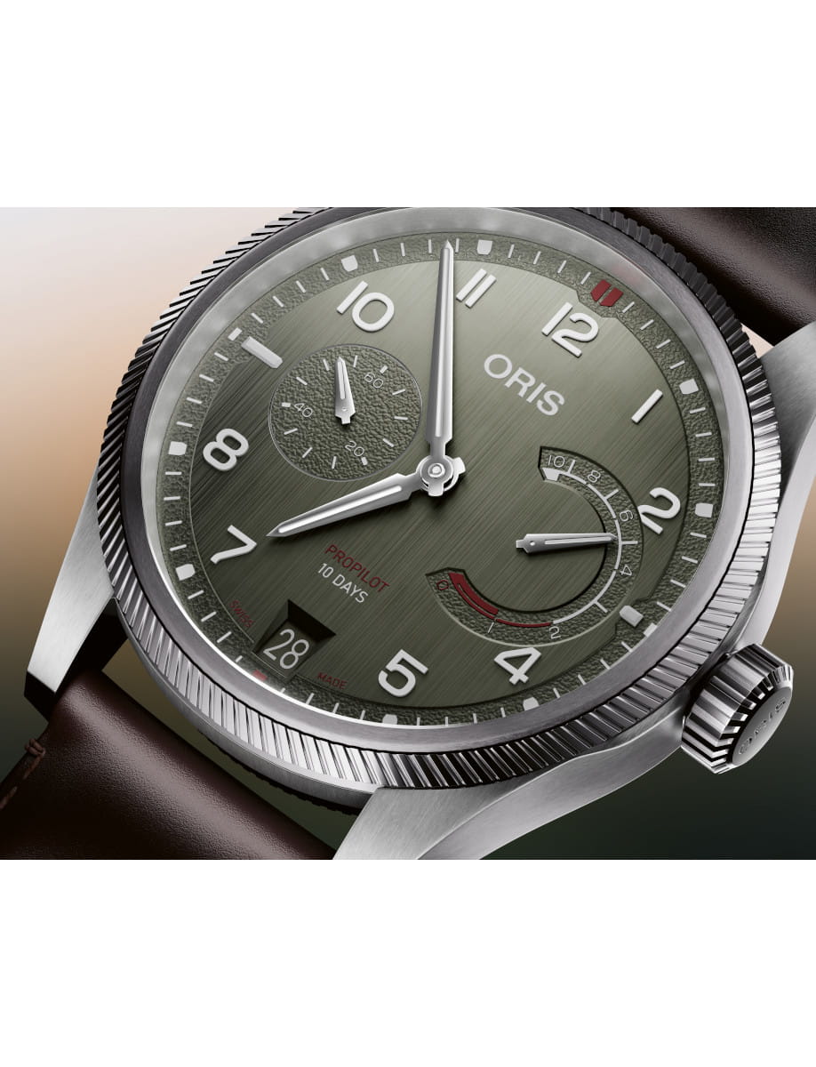 Close-up of an Oris ProPilot 10 Days wristwatch with a green dial, sub-dials, date window at 6 o'clock, and brown leather strap