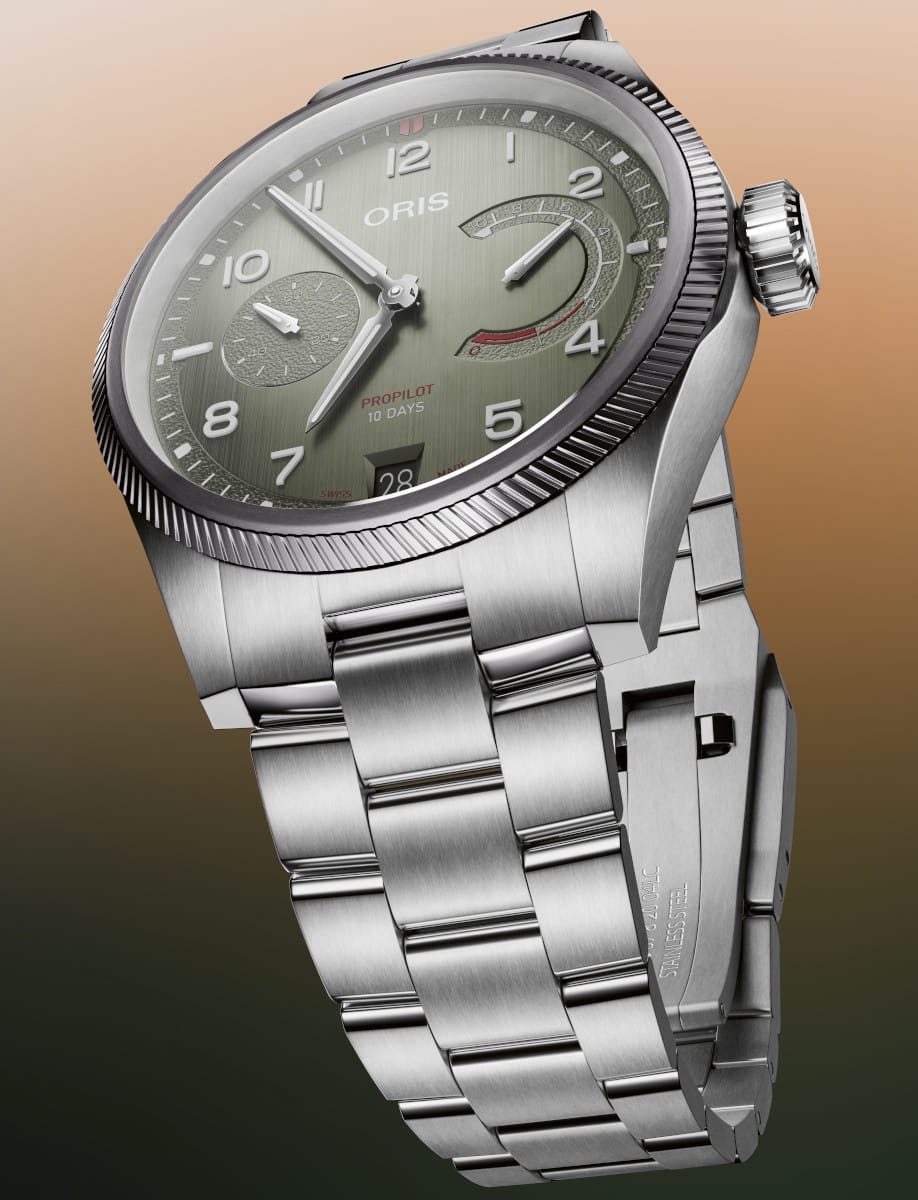 Oris Propilot wristwatch with green dial, stainless steel case and bracelet, date window at 6 o'clock and power-reserve indicator visible on the right side