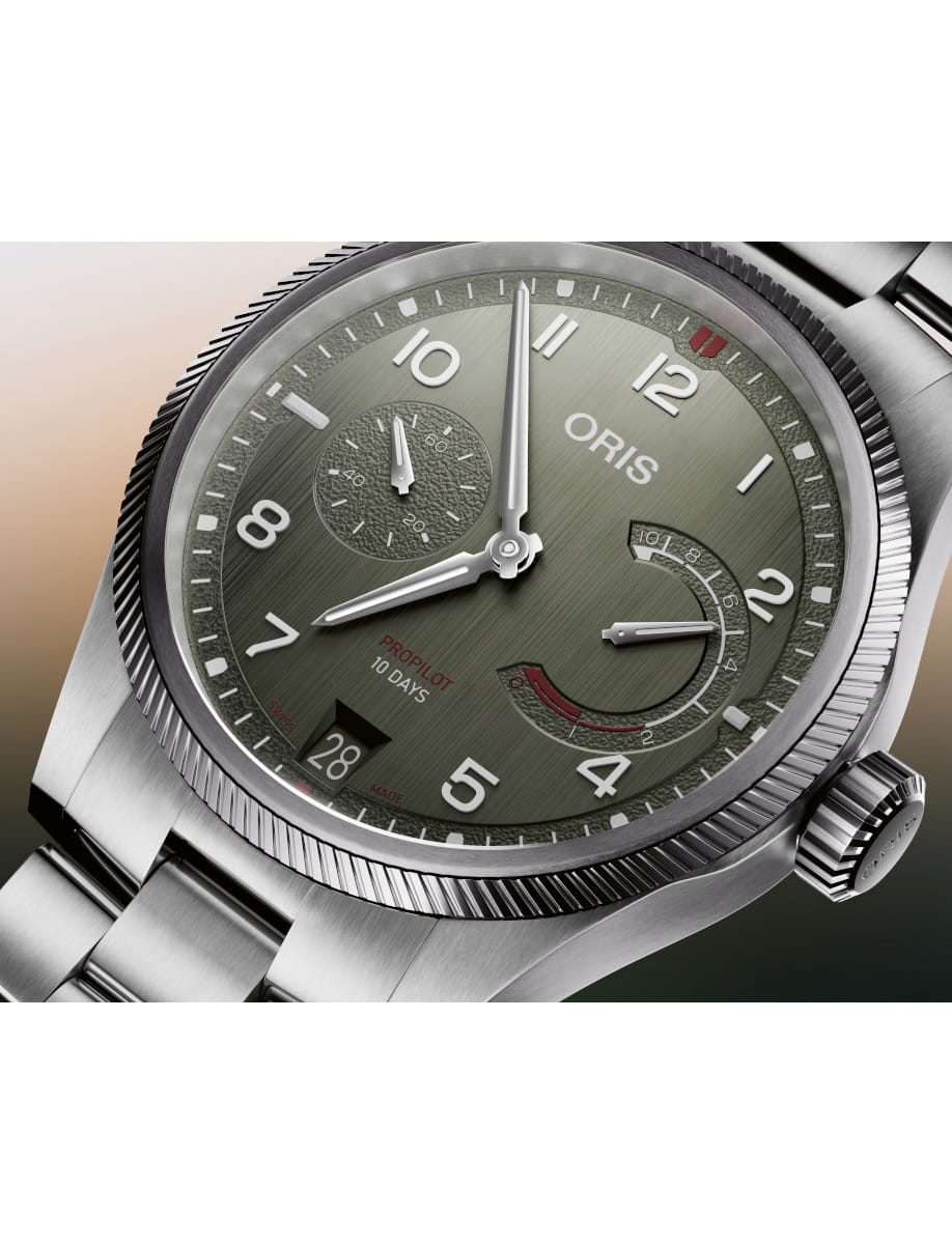 Close-up of an Oris ProPilot 10 Days wristwatch with a green dial and stainless steel case and bezel.