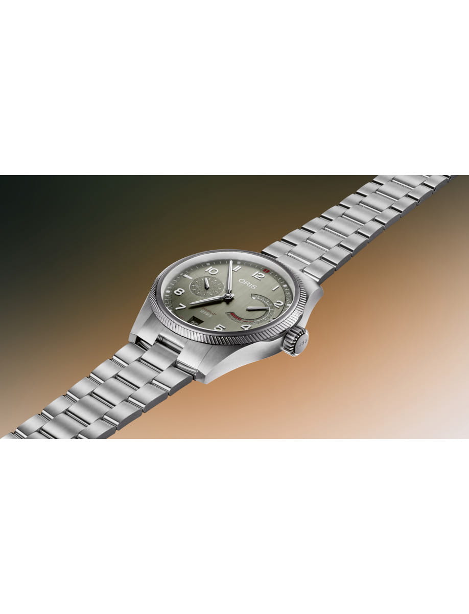 Oris stainless steel wristwatch with a green dial and steel link bracelet, angled to the right.