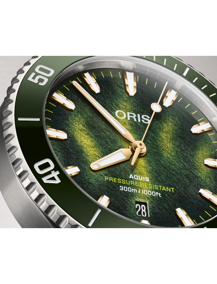 Close-up of an Oris Aquis watch with a ocean green dial, luminous hands and markers, and a date window showing 28.