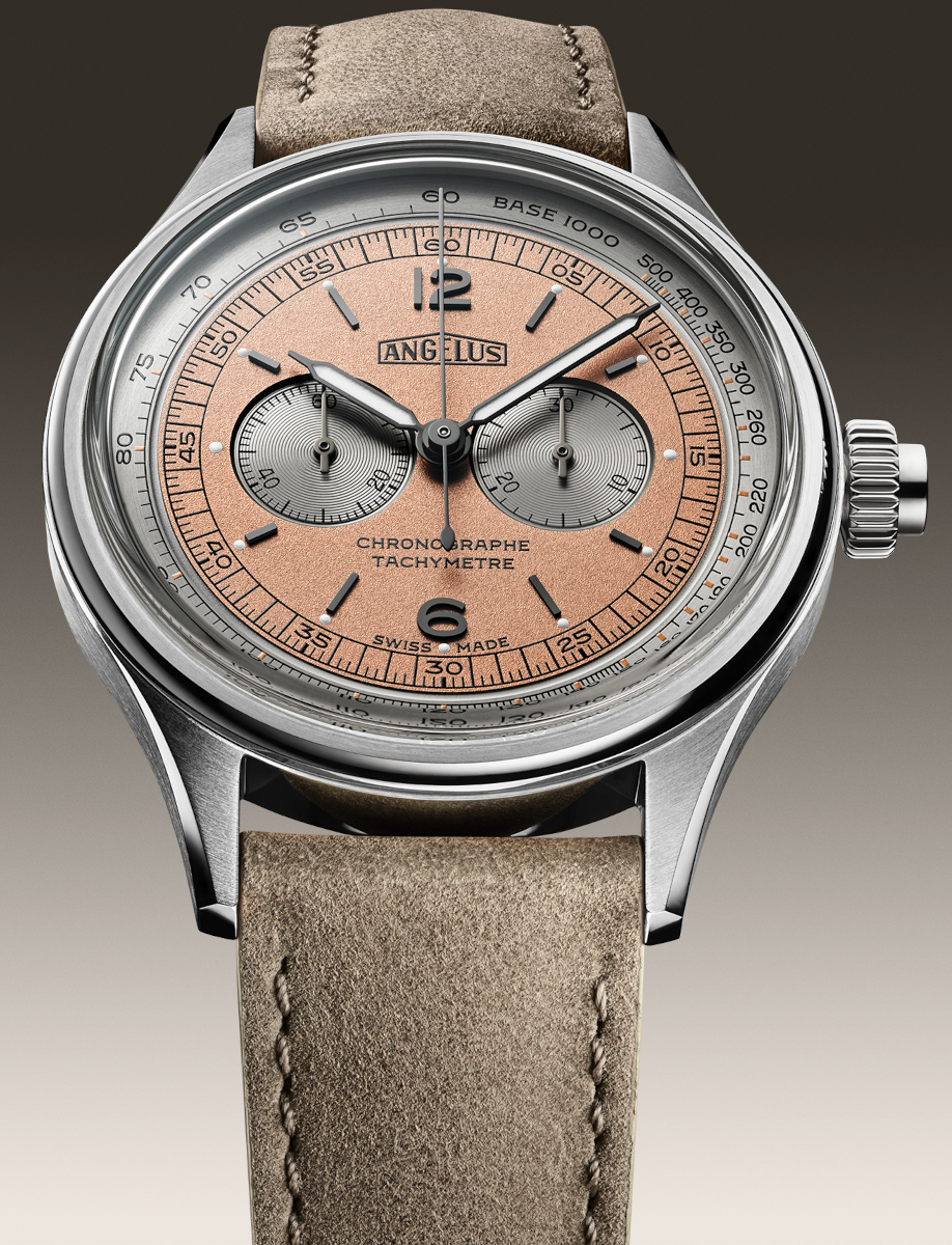 Close up view of Angélus chronograph watch with stainless steel case, coral-pink dial, tachymeter scale, and sepia grey leather strap.