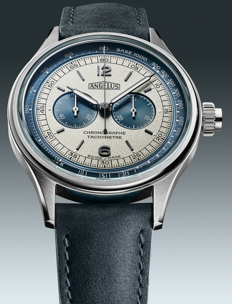 Close up of Angélus chronograph watch with stainless steel case, blue and grey dial, tachymeter scale, and blue calf leather strap.
