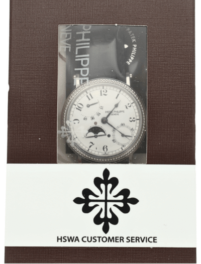 Close-up of a silver analog wristwatch displayed in a brown textured presentation box with an HSWA Customer Service band/logo beneath.