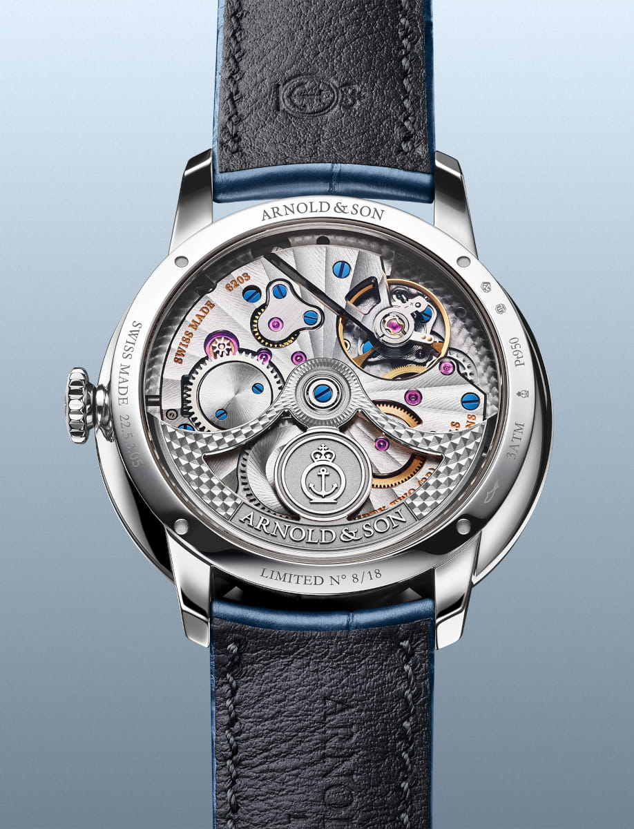 Back view of an Arnold&Son luxury watch revealing the intricate mechanical movement with blue screws and jewels, Arnold & Son, Limited No. 8/18.