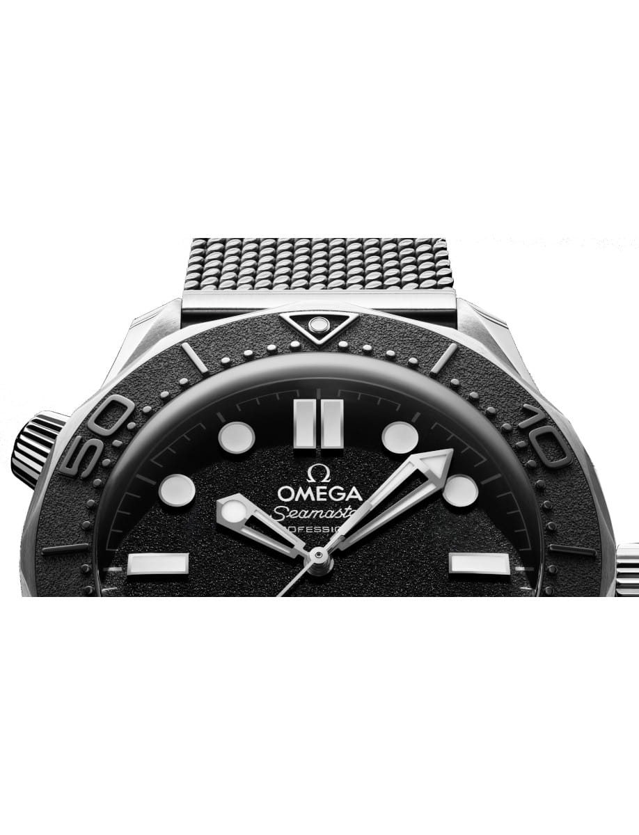 Close-up of an Omega Seamaster Professional watch face with a black dial, bold indices, and a mesh bracelet visible at the top edge.