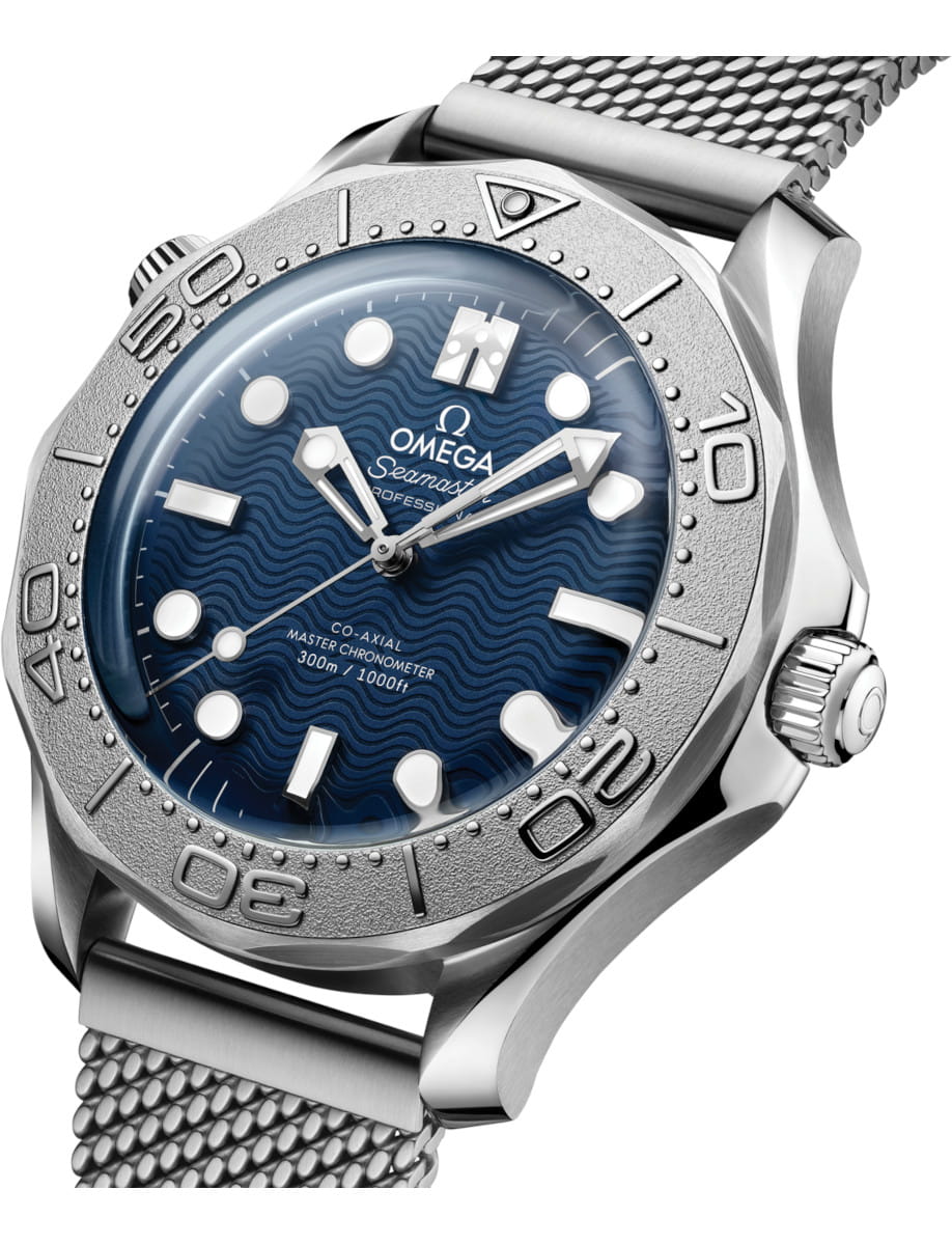Omega Seamaster dive watch with blue wavy dial, stainless steel case and mesh bracelet, showing 300m/1000ft water resistance and bezel markers