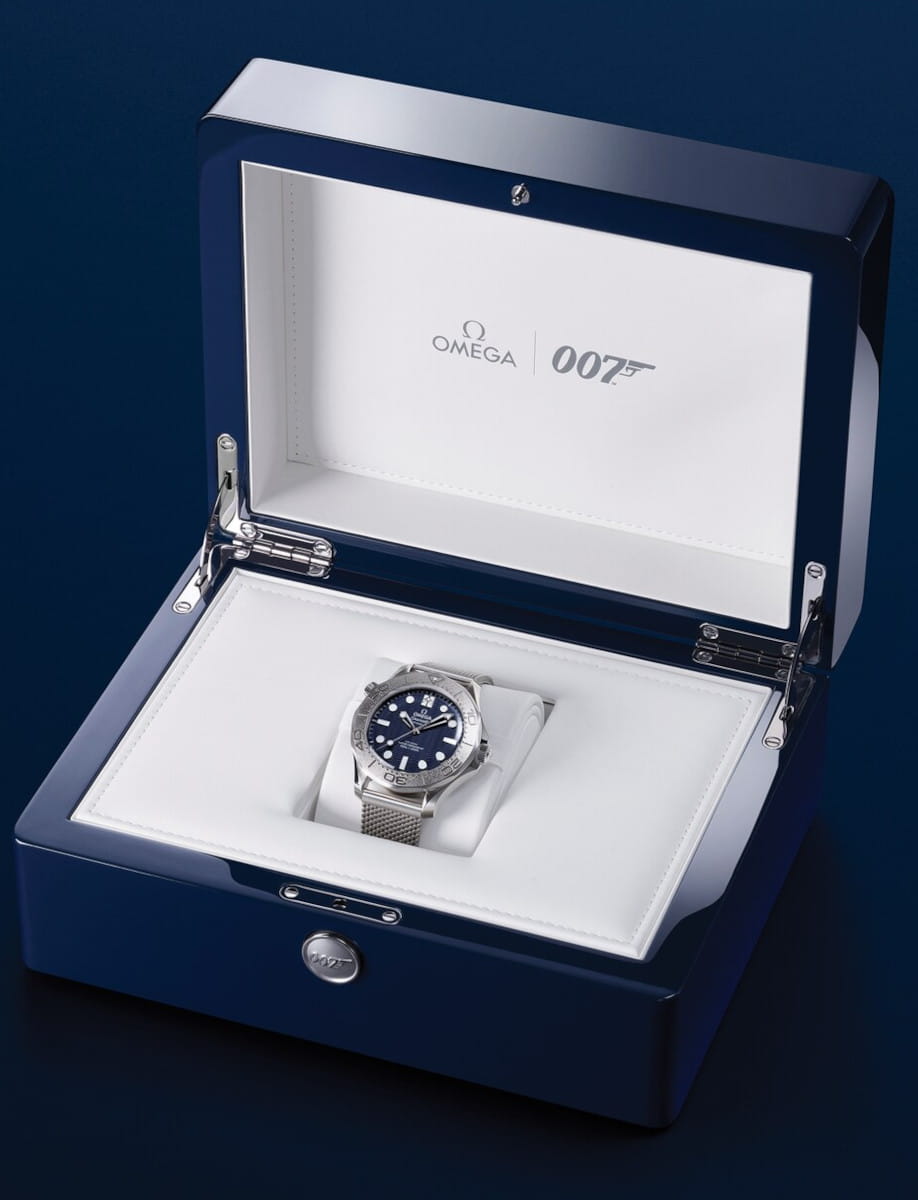 Omega x 007 wristwatch in a blue glossy presentation box with a white interior.