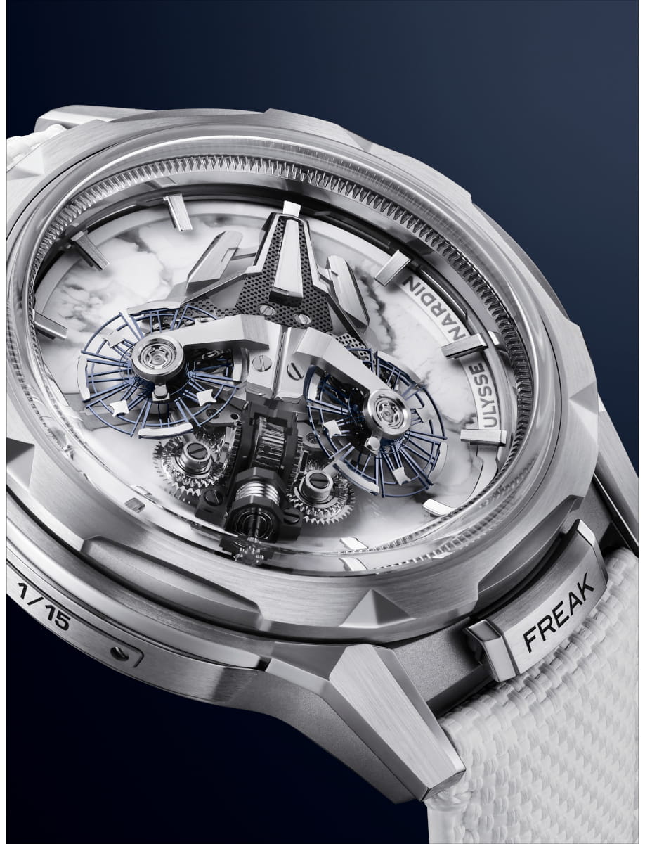 Close up view of Ulysse Nardin Freak skeleton wristwatch with a white and grey veining dial and white rubber strap, and titanium case.
