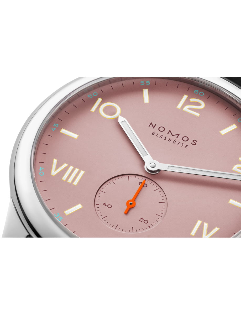 Close up of NOMOS Glashütte wristwatch with a pink dial, stainless steel case