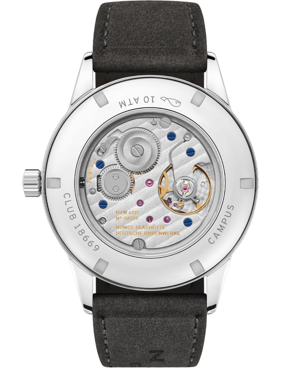 Back of a stainless steel wristwatch showing its exposed mechanical movement with gears, screws, and a black leather strap.